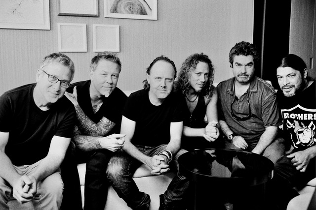 A black and white photo of men sitting in a room.